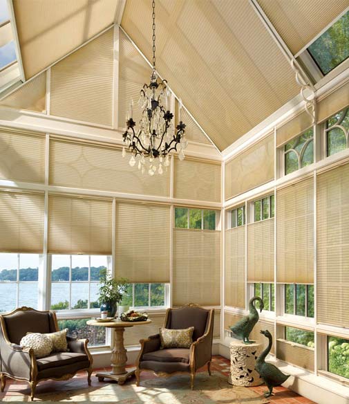 A tastefully decorated home with glass ceilings and walls that are concealed with cellular blinds.